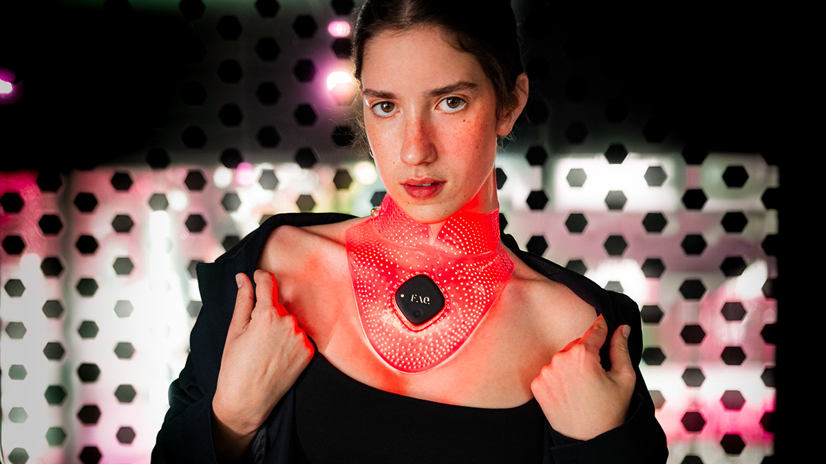 FAQ 211 Anti-Aging LED Neck & Décolleté Mask on a model with dark hair and dark eyes 